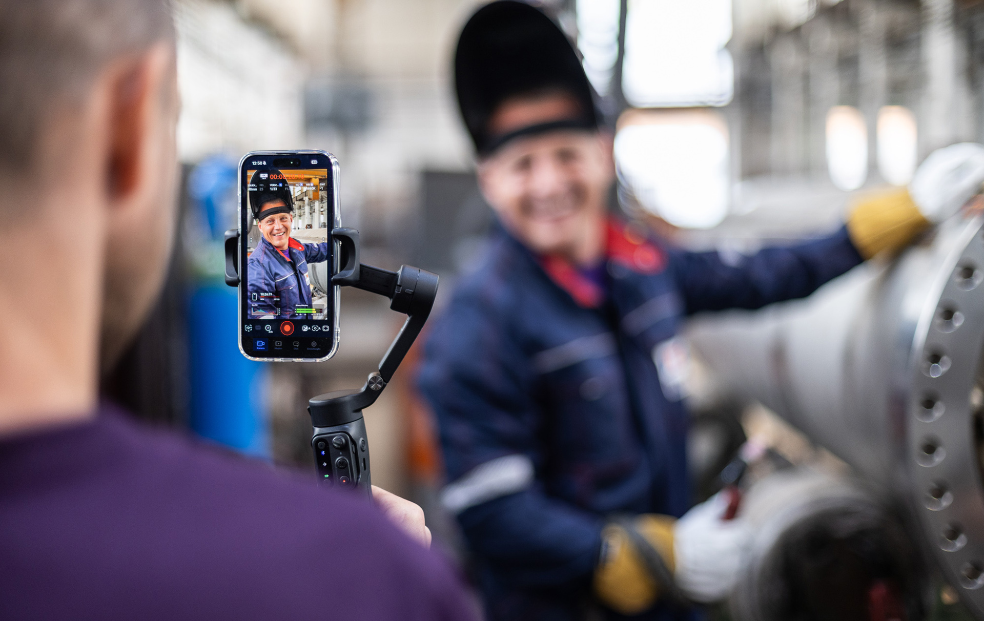 Foto: Auf einem Handy ist die Arbeitsszene sichtbar