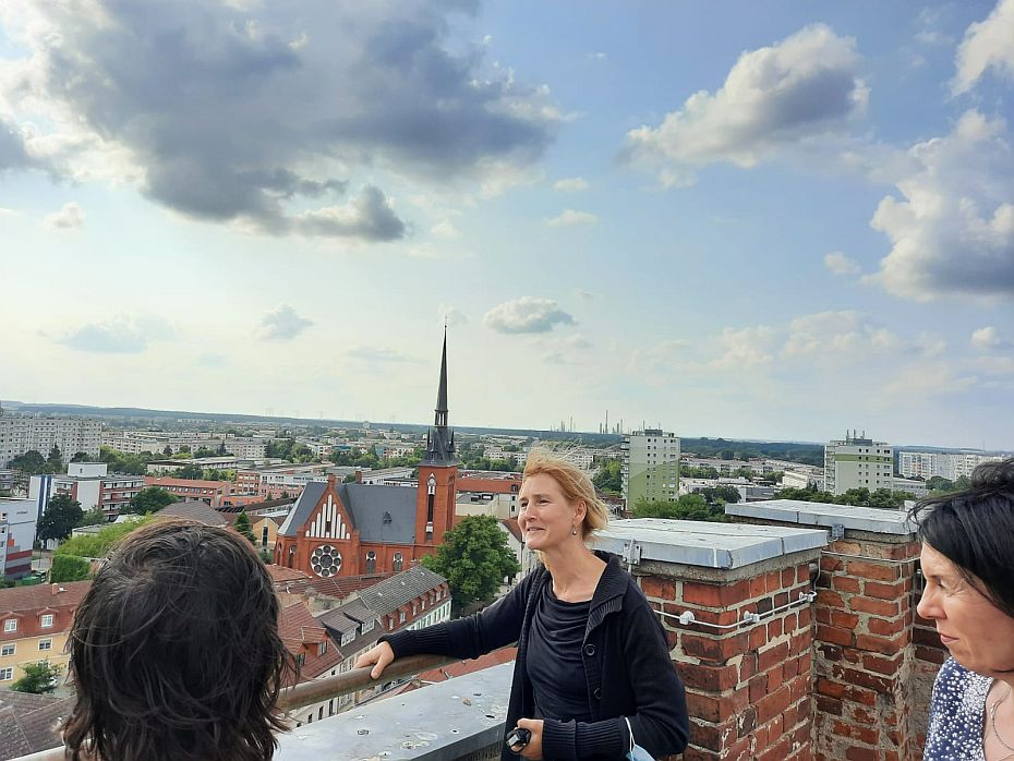 Menschen stehen auf dem Kirchturm und schauen auf die Landschaft.