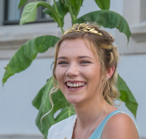 Eine hübsche,  junge Frau mit blonden Haaren und einer Krone 