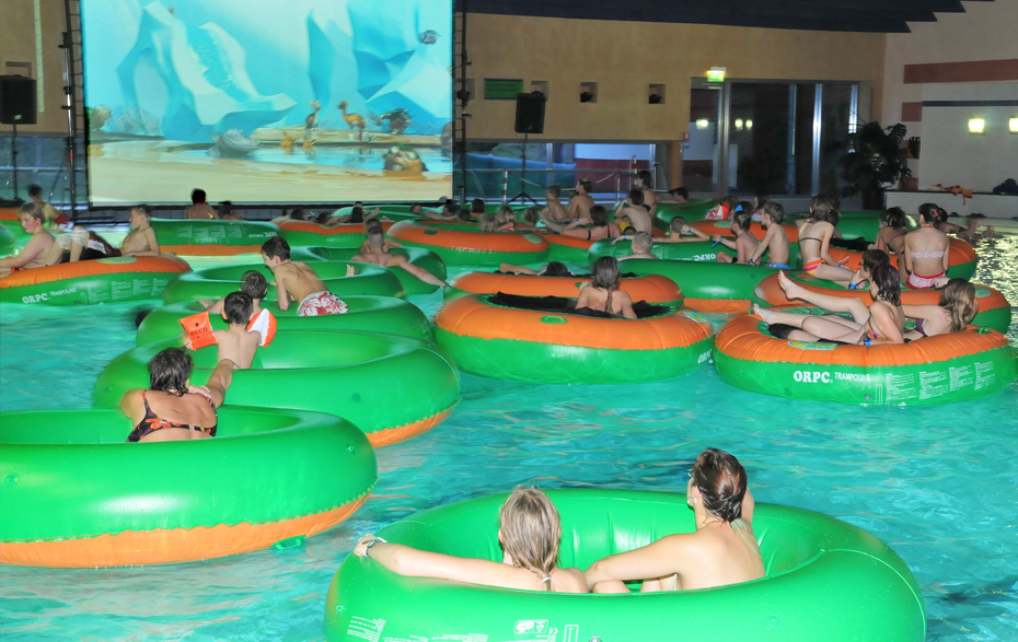 Foto: Zuschauer hängen in großen Schwimmringen.