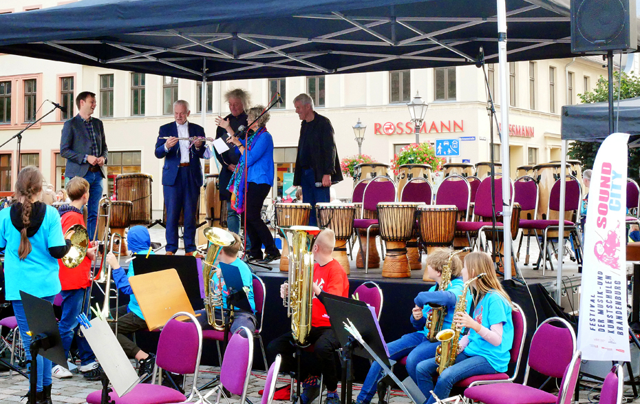 Foto: Übergabe eines Instrumentes an den Bürgermeister auf der Bühne