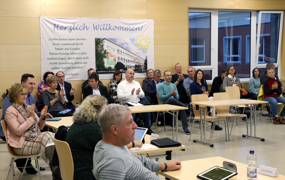 Foto: mehrere Personen sitzen in der Aula