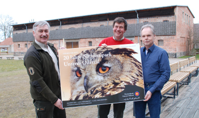 Foto: 3 Männer mit Werbeplakat