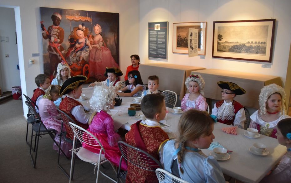 Kinder sitzen verkleidet am Tisch