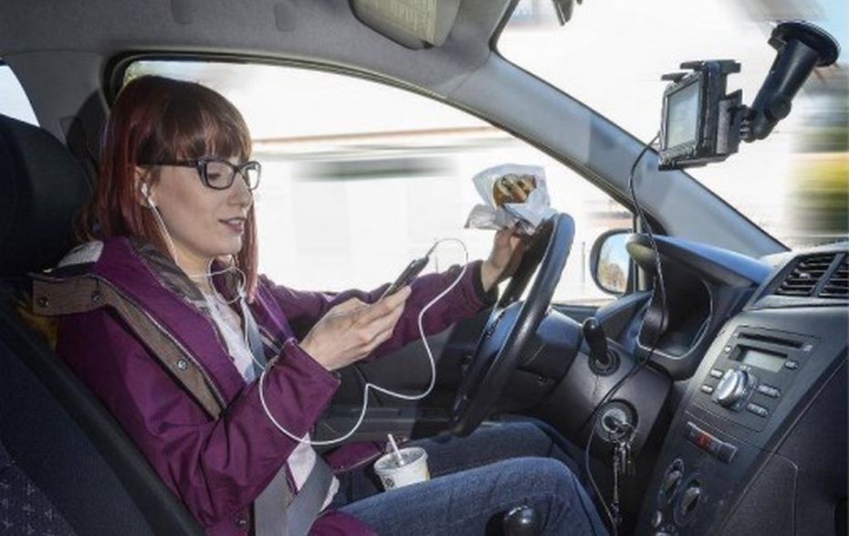 Frau fährt Auto und telefoniert dabei.