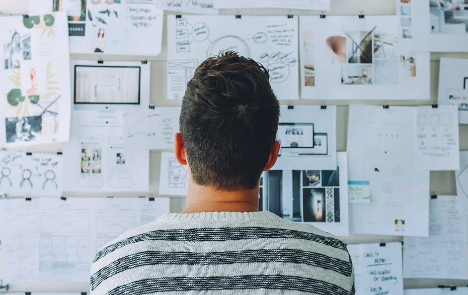 Foto: Mann vor einem Whiteboard mit vielen Zetteln