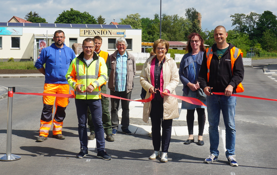 Gruppenfoto: 3 Personen schneiden das rote Band durch