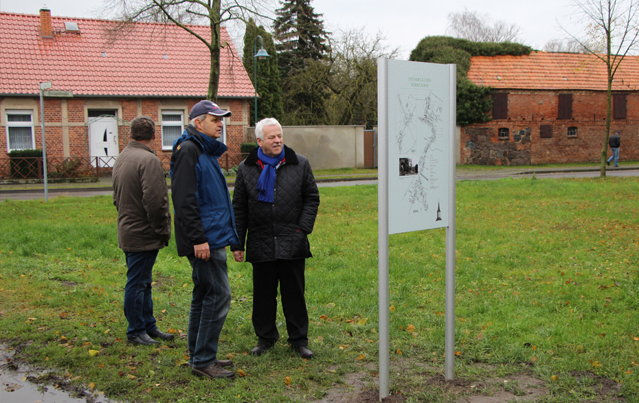 Foto: 3 Männer vor der Informationstafel