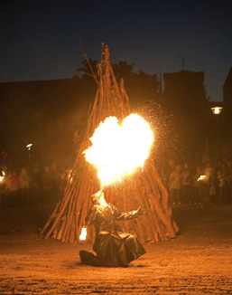 Foto: Feuershowkünstler vor dem Holzstapel