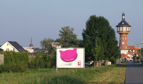 Foto: Heinersdorfer Damm mit Eigenheimen hinter der Mauer und rechts dem  Wasserturm