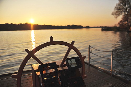 Foto: Steuerrad mit Blick aufs Wasser