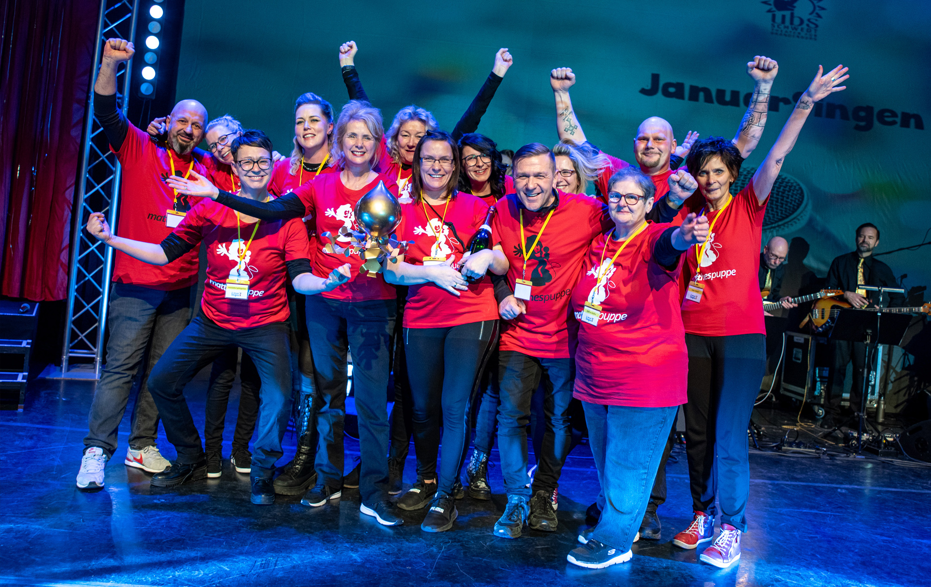 Gruppenfoto: jubelndes Siegerteam mit Preisen