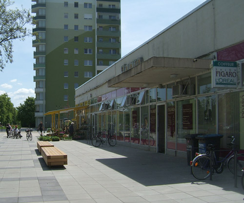 Foto: Friseur und Blumenladen im Kompaktbau vor dem Hochhaus Lindenallee