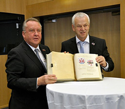 Foto: Zwei Männer halten das Goldene Buch zum Fotografen.