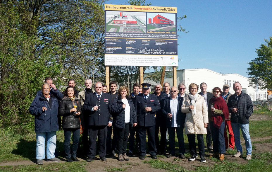 Gruppenfoto vor dem Bauschild