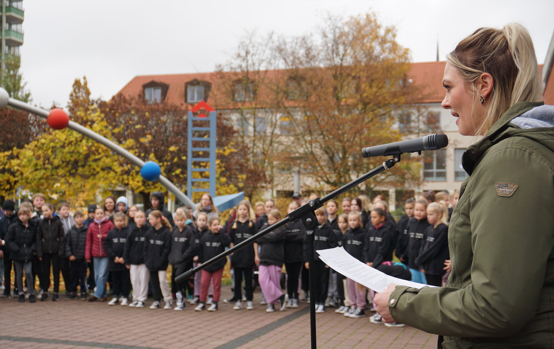 Foto: Frau am Mikrofon vor Publikum