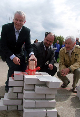 Foto: 3 Personen versenken eine Kupferhülse im Mauerwerk.