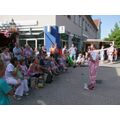 Foto: Clown mit rosa Luftballonschlange vor Familien mit kleinen Kindern