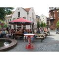 Foto: Menschen sitzen am Vierradener Platz in einem Biergarten.