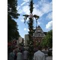 Foto: Mittsommerstange vor dem Giebel der ehemaligen Stadtmühle, vorn Festbesucher