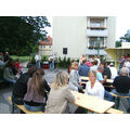 Foto: Leute sitzen auf Bierbänken.