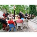 Foto: Galeriegäste sitzen im Garten und applaudieren.