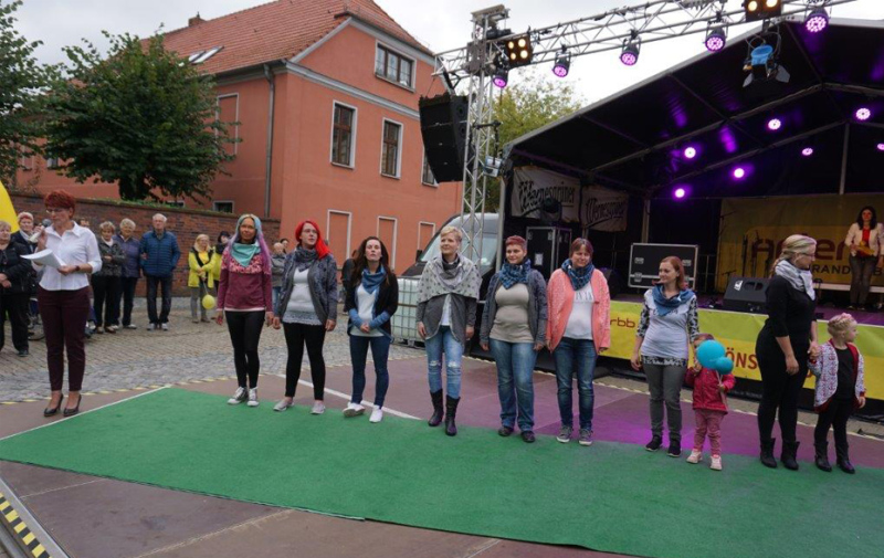 Foto: Frauen und 2 Kinder stehen auf der Bühne in einer Reihe