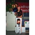 Foto: Sportlerin mit Pokal, Geschenk und Blumen