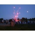 Foto: Publikum steht am Ufer und betrachtet das Feuerwerk.