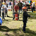 Foto: Ein Junge mit Spritze und Helm und ein Junge an der Wasserpumpe