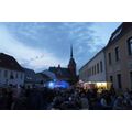 Foto: gut gefüllter Platz mit Bühne und katholischer Kirche