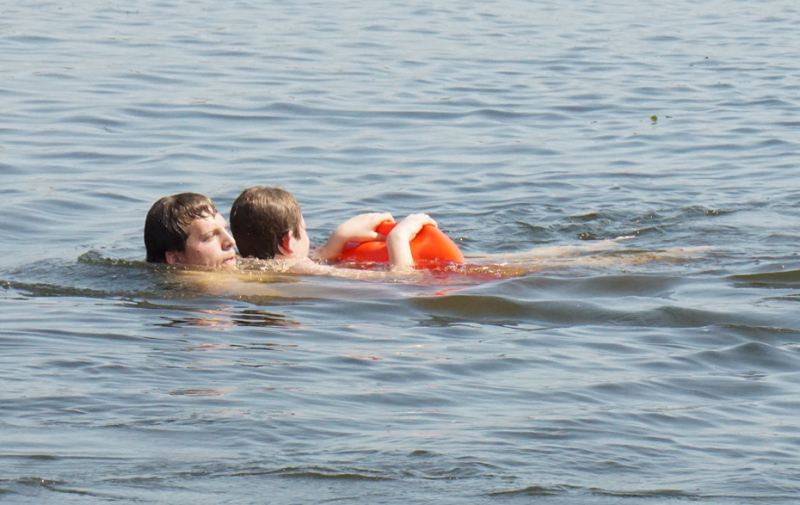 Foto: Rettungsschwimmer schwimmt im Wasser mit einem zu Rettenden im Arm Foto: Rettungsschwimmer schwimmt im Wasser mit einem zu Rettenden im Arm