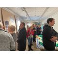 Menschen im Ausstellungsraum beim Reden und Betrachten der Ausstellungstafeln