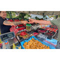 Foto: Händlerin am Obststand übergibt ein Eimerchen mit Gurken