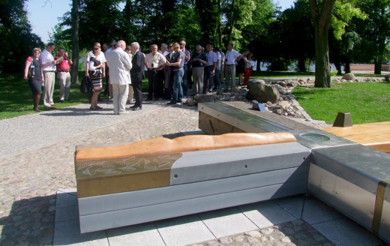 Foto: An der Sitzlandschaft „Hugenottekreuz“ unterhalten sich diverse Personen.