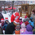 Foto: Kinder umringen den Weihnachtsmann und schauen in den Sack.