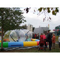 Foto: diverse Kinder laufen in einem Ball ein einem Wasserbassin.