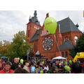 Foto: Bühnenpublikum mit nebenstehender katholischer Kirche