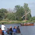 Foto: Wartende auf dem Anleger, im Hintergrund das fahrende Boot