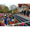 Foto: Bürgermeister, Rektorin und drei Schüler stehen oberhalb einer Treppe und am Treppenrand eine Scharr Kinder.