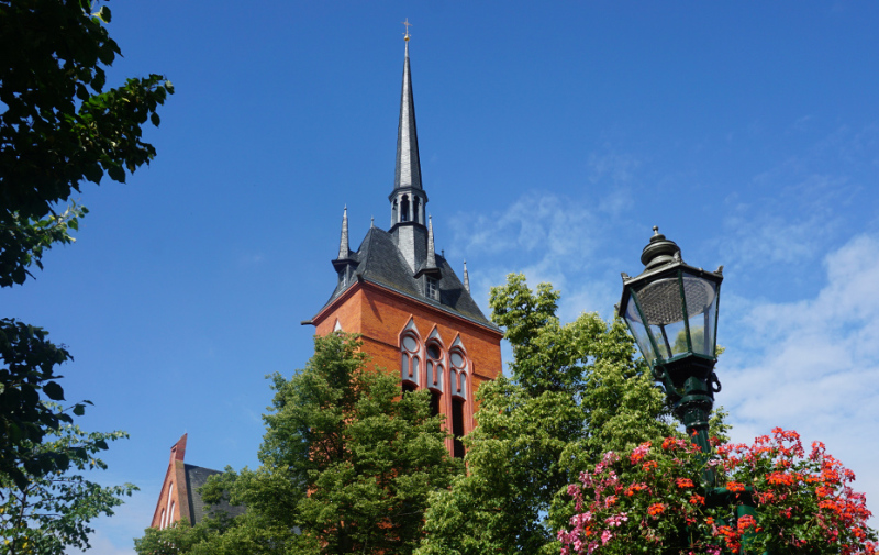 Foto: Turm der Kirche und Laterne mit Blumen Foto: Turm der Kirche und Laterne mit Blumen
