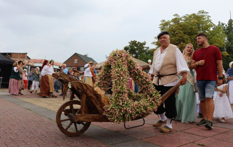 Verkleidete in Hugenotten-Kostüm bringen die Tabakkrone aus den Tabakblumen auf den Markt in Vierraden. Hinter der Tabakkrone ist die Tabakkönigin Luisa Müller.