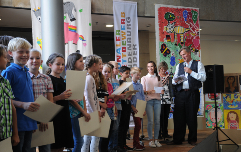 Foto: Kindergruppe und Moderator auf der Bühne