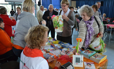 Foto: Besucher am Stand einer Apotheke